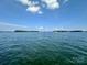 Expansive lake view with calm waters under a blue sky dotted with fluffy white clouds at 7794 Live Oaks Dr, Denver, NC 28037