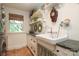 Bright laundry room featuring a farmhouse sink, unique flooring, and ample storage at 7794 Live Oaks Dr, Denver, NC 28037