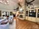 Cozy living room featuring a stone fireplace, vaulted ceiling, and hardwood flooring at 7794 Live Oaks Dr, Denver, NC 28037