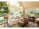 Sun-drenched living room boasts large arched windows, hardwood floors, and comfortable seating at 7794 Live Oaks Dr, Denver, NC 28037