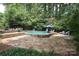 Backyard pool with stone patio, mature trees and lush landscaping and multiple seating areas at 7794 Live Oaks Dr, Denver, NC 28037