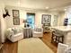 Cozy seating area adjacent to kitchen featuring white armchairs, side table, and beautiful natural light at 7794 Live Oaks Dr, Denver, NC 28037
