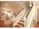 Classic staircase with wood steps, white railings, and natural light, connecting the home's floors with style and elegance at 7794 Live Oaks Dr, Denver, NC 28037