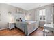 Serene bedroom featuring a white wooden bed frame, hardwood floors, and natural light from the window at 8125 Appaloosa Ln, Charlotte, NC 28215