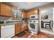 Galley kitchen featuring wood cabinets, white appliances, and natural lighting at 8125 Appaloosa Ln, Charlotte, NC 28215
