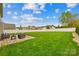 Expansive backyard with lush green grass, complemented by a patio seating area and a white fence at 963 Brookdale Ln, Stanley, NC 28164