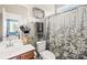 Cozy bathroom with decorative towels, a floral shower curtain, and a wooden vanity with a sink, offering comfort and style at 963 Brookdale Ln, Stanley, NC 28164