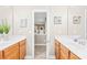 Bathroom featuring double vanities with wood cabinets and mirrors, plus a doorway to the hall at 963 Brookdale Ln, Stanley, NC 28164