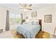 Bright bedroom featuring a large window, ceiling fan, and a cozy bed with decorative pillows at 963 Brookdale Ln, Stanley, NC 28164