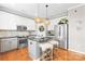 Kitchen features white cabinets, a kitchen island, stainless appliances, and hardwood floors at 963 Brookdale Ln, Stanley, NC 28164