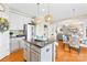 Open kitchen with white cabinets, stainless appliances, hardwood floors, and kitchen island at 963 Brookdale Ln, Stanley, NC 28164