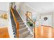 Elegant foyer with hardwood floors and a staircase featuring a decorative iron railing at 963 Brookdale Ln, Stanley, NC 28164