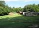 Wide view of backyard with fenced area and multiple homes on the same lot, needs TLC at 1000 Jl Tyson Dr, Gastonia, NC 28056