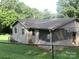 View of a single story home with light siding, dark roof, and fenced yard, needs TLC at 1000 Jl Tyson Dr, Gastonia, NC 28056