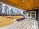 Back porch with wooden floors and ceiling overlooking a manicured backyard at 1022 Harrogate Dr, Bessemer City, NC 28016