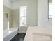 Bright bathroom featuring a soaking tub, gray tiled walls, and black tile floor at 1022 Harrogate Dr, Bessemer City, NC 28016