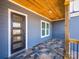 Stylish front porch with a stone tile floor, wood ceiling, and a modern front door at 1022 Harrogate Dr, Bessemer City, NC 28016