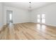 A living room with light hardwood floors and double doors to the outside at 1022 Harrogate Dr, Bessemer City, NC 28016