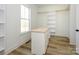 Walk-in closet featuring a central island, bright white shelves, and wood floors at 1022 Harrogate Dr, Bessemer City, NC 28016