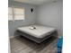 Bedroom with light gray walls, light gray wood grain flooring, windows, and a bed at 1111 Pondella Dr # 66, Charlotte, NC 28213