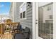 Charming balcony featuring dark wicker chairs, a small black table, and a wooden deck at 1129 Doveridge St, Charlotte, NC 28273