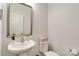 Bathroom features a pedestal sink, silver framed mirror, and white commode at 1129 Doveridge St, Charlotte, NC 28273