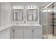 Well-lit bathroom with double sinks, white cabinets and a glass shower at 1129 Doveridge St, Charlotte, NC 28273