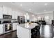 Open kitchen with large island, stainless appliances and dark hardwood floors open to the living room at 1129 Doveridge St, Charlotte, NC 28273