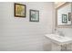 Stylish half-bathroom featuring shiplap walls, a pedestal sink, and decorative artwork at 125 Lanyard Dr # E, Mooresville, NC 28117
