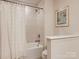 Bright bathroom featuring a shower-tub combo with a white shower curtain and tiled walls at 125 Lanyard Dr # E, Mooresville, NC 28117