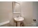 Bathroom with pedestal sink, large mirror, and light neutral walls at 15308 Lake Ridge Rd, Charlotte, NC 28278