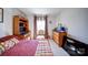 Bedroom with a full desk, dresser, window, and bright, natural light at 15308 Lake Ridge Rd, Charlotte, NC 28278