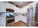 Modern kitchen with stainless steel appliances, white cabinets, and quartz countertops at 15308 Lake Ridge Rd, Charlotte, NC 28278
