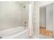 Bright bathroom with a tub-shower combo, mosaic tile wall, and glass shelving at 1665 Sterling Rd, Charlotte, NC 28209