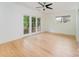 A bright and airy bedroom with hardwood floors, ceiling fan, and double doors to a balcony at 1665 Sterling Rd, Charlotte, NC 28209