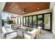 Inviting covered porch has wood ceiling, seating, and sliding glass doors to the interior at 1665 Sterling Rd, Charlotte, NC 28209