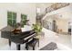 Bright, open foyer showcasing a grand piano and a curved staircase with decorative iron railings and marble tile floors at 1665 Sterling Rd, Charlotte, NC 28209
