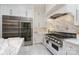 Gourmet kitchen featuring custom white cabinets, stainless steel appliances, marble countertops, and elegant finishes at 1665 Sterling Rd, Charlotte, NC 28209