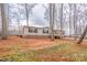 Beige home with black shutters and a porch, nestled amongst mature trees on the property at 1795 Kestrel Valley Ln, Catawba, NC 28609