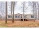 Beige home with black shutters, a brick foundation, and a welcoming front porch at 1795 Kestrel Valley Ln, Catawba, NC 28609