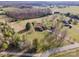 Sprawling countryside estate featuring a large home with a detached garage, surrounded by trees and open fields at 190 Country Dr, Statesville, NC 28625