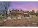 View of landscaped backyard with patio, seating areas, and a water feature at 190 Country Dr, Statesville, NC 28625
