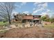 Beautifully landscaped backyard with brick patio, outdoor seating, and mature trees at 190 Country Dr, Statesville, NC 28625