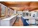 Bright kitchen with white countertops, mosaic backsplash, blue island, and wood ceiling at 190 Country Dr, Statesville, NC 28625