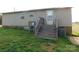 The back of this property features a door with stairs and lawn at 1909 E Lawyers Rd, Monroe, NC 28110