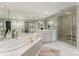 A luxurious bathroom with a large soaking tub, glass block shower, and dual sink vanities at 2445 Selwyn Ave, Charlotte, NC 28209