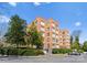 Exterior view of the brick condo building complex with a circular driveway, landscaping, and a car at 2445 Selwyn Ave, Charlotte, NC 28209