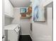Neat laundry room features white cabinetry, stylish decor, shelving, modern washer and dryer on black hardwood floors at 2445 Selwyn Ave, Charlotte, NC 28209
