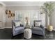 Cozy sitting area with upholstered chairs, tufted ottoman, and a decorative tree creating a serene retreat at 2445 Selwyn Ave, Charlotte, NC 28209
