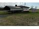 View of the backyard featuring an open field, shed, and covered parking area attached to the house at 2730 Medlin Rd, Monroe, NC 28112